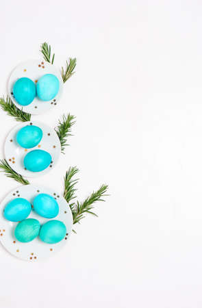 Colored eggs on plate with on white background. Flat lay. Copy space. Easter concept. Top view.の写真素材