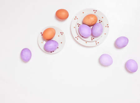Colored eggs on plate with on white background. Flat lay. Copy space. Easter concept. Top view.の写真素材