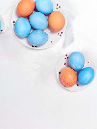 Colored eggs on plate with on white background. Flat lay. Copy space. Easter concept. Top view.の写真素材