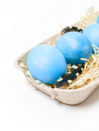 Easter eggs in a carton box on a white background.の写真素材