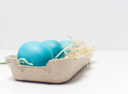 Easter eggs in a carton box on a white background.の写真素材
