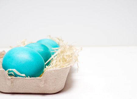 Easter eggs in a carton box on a white background.の写真素材