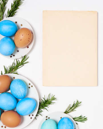 Colored eggs on plate with on white background. Flat lay. Copy space. Easter concept. Top view.の写真素材