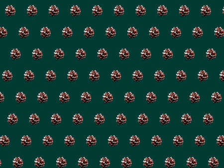 Christmas cones pattern. New Year decorations on green background. Flat lay, top view.の写真素材