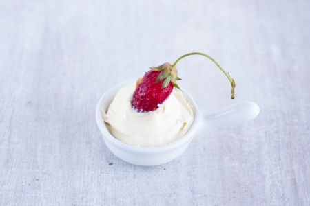 sweet strawberry and sour cream on the white sauceboatの写真素材