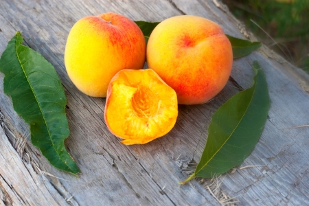 rich summer peachs and leafson the wood plankの写真素材