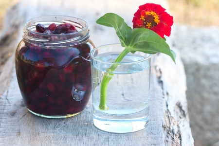  tumbler with red flower and pot with sweet preserve of berry