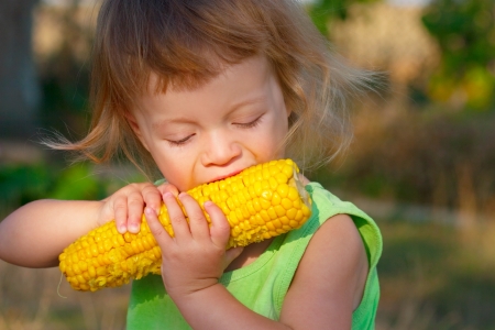 nice small child to eat boiled corncobの写真素材