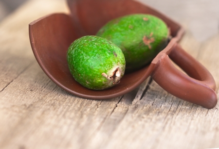 feijoa in clay shard on wooden boardsの写真素材
