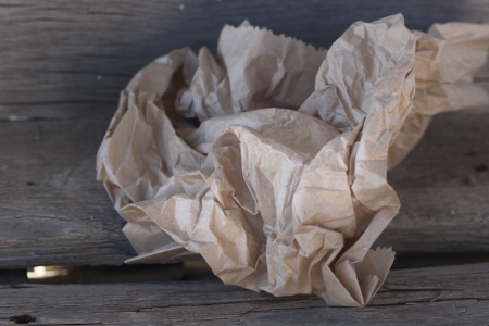 crumpled paper bag on the old dark wood boardの写真素材