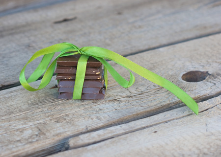 milk chocolate in the green ribbon on the wood boardの写真素材