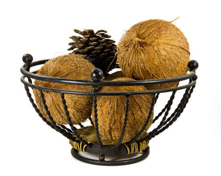 Couple of coconuts and a pine cone in a metal basket