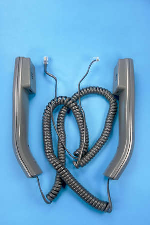 Two unplugged phone handsets on blue backgroundの写真素材