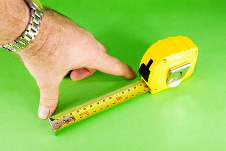 Yellow measuring tape on green background