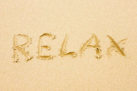 Sandy beach with word Relax written on sandの写真素材