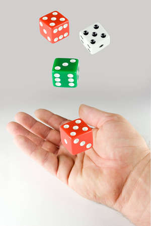 Hand and a set of dice on gray backgroundの写真素材