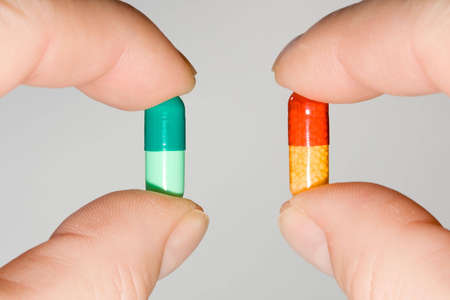 Two pills held side to side in each hand