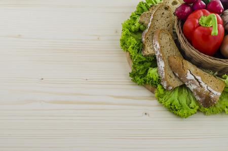 Composition of bread and vegetables on wooden table.の写真素材