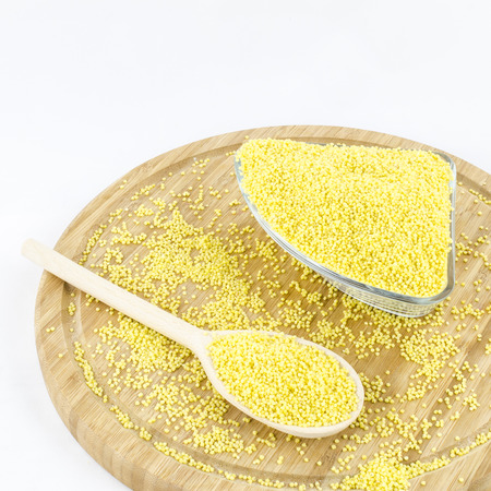 Millet groats on wooden board. Healthy vegetaria food.の写真素材