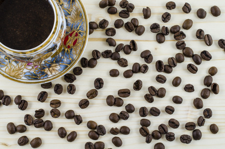 Porcelain coffee cup and coffee beans on wooden tableの写真素材