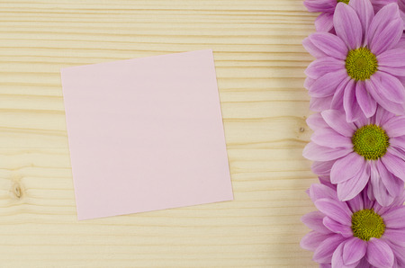 Blank pink card and pink flowers on wooden backgroundの写真素材