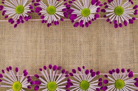 Frame of colorful flowers and pink ribbon on linen backgroundの写真素材