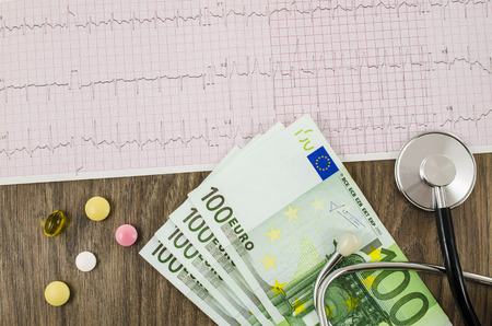 Electrocardiogram with pills, money and stethoscopeの写真素材