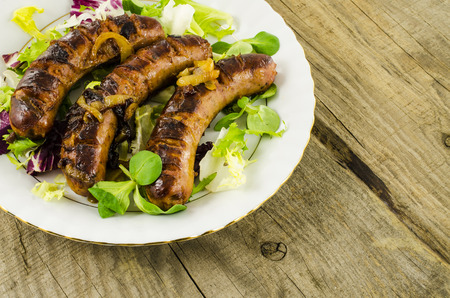 Roasted sausage with vegetables on wooden backgroundの写真素材