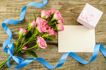 Empty postcard, flower and blue ribbon on wooden の写真素材