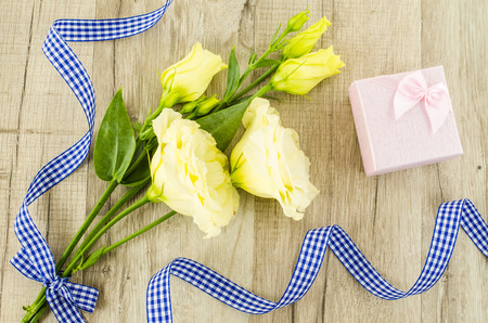 Yellow flower and gift box on wooden の写真素材