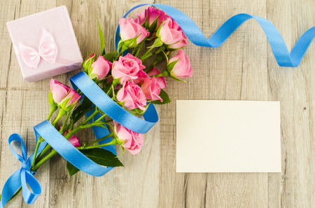 Empty postcard, flower and blue ribbon on wooden の写真素材