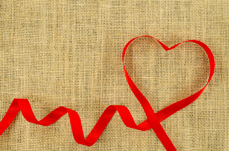 Heart shaped ribbon on linen backgroundの写真素材
