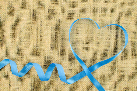 Heart shaped ribbon on linen backgroundの写真素材