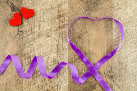Heart shaped ribbon on wooden backgroundの写真素材