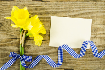 Empty card with flower and ribbon on wooden backgroundの写真素材