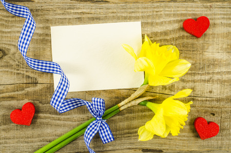 Empty card with flower and ribbon on wooden backgroundの写真素材