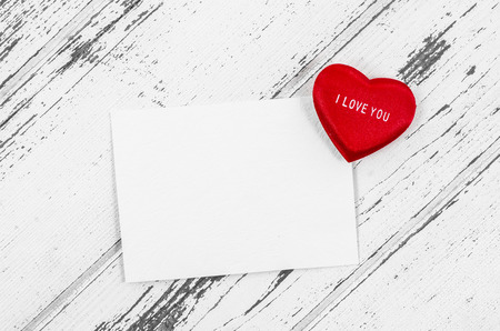 Empty card with heart on wooden tableの写真素材