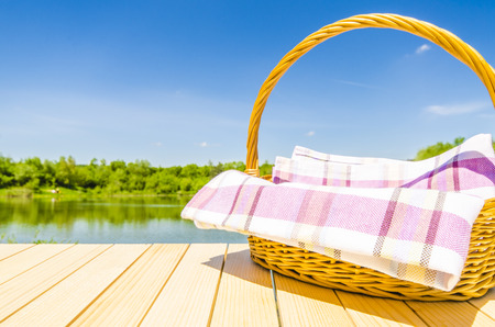 Picnic basket on wooden table with landscape backgroundの写真素材