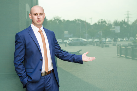 Young fashionable man in a suit against city backgroundの写真素材