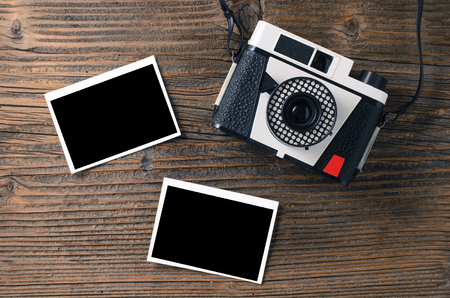 Vintage camera and old photos on wooden tableの写真素材