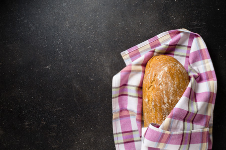 Loaf of bread on dark tableの写真素材