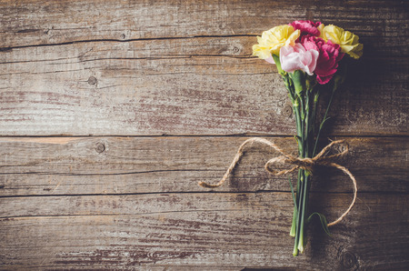 Carnation flowers on wooden tableの写真素材