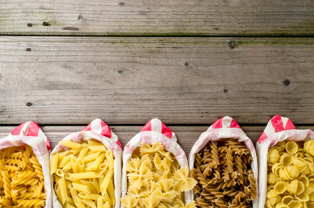 Pasta in paper bag on wooden tableの写真素材