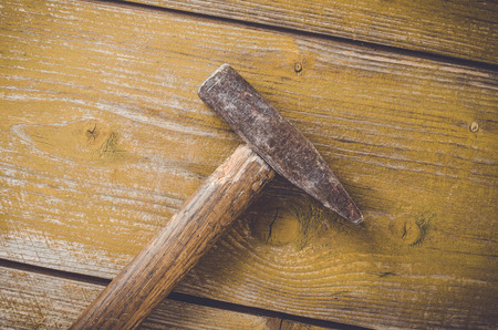 Old rusty hammer on wooden tableの写真素材