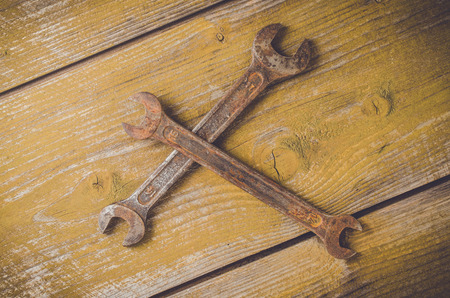 Old rusty wrench on wooden table