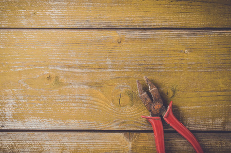Old rusty pliers on wooden table