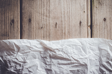 Sheet of crumpled paper on an old wooden tableの写真素材