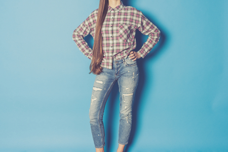 Young fashionable woman against blue backgroundの写真素材