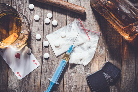Hard drugs and alcohol on an old wooden tableの写真素材