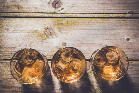 Overhead shot of glasses of whiskey on wooden tableの写真素材